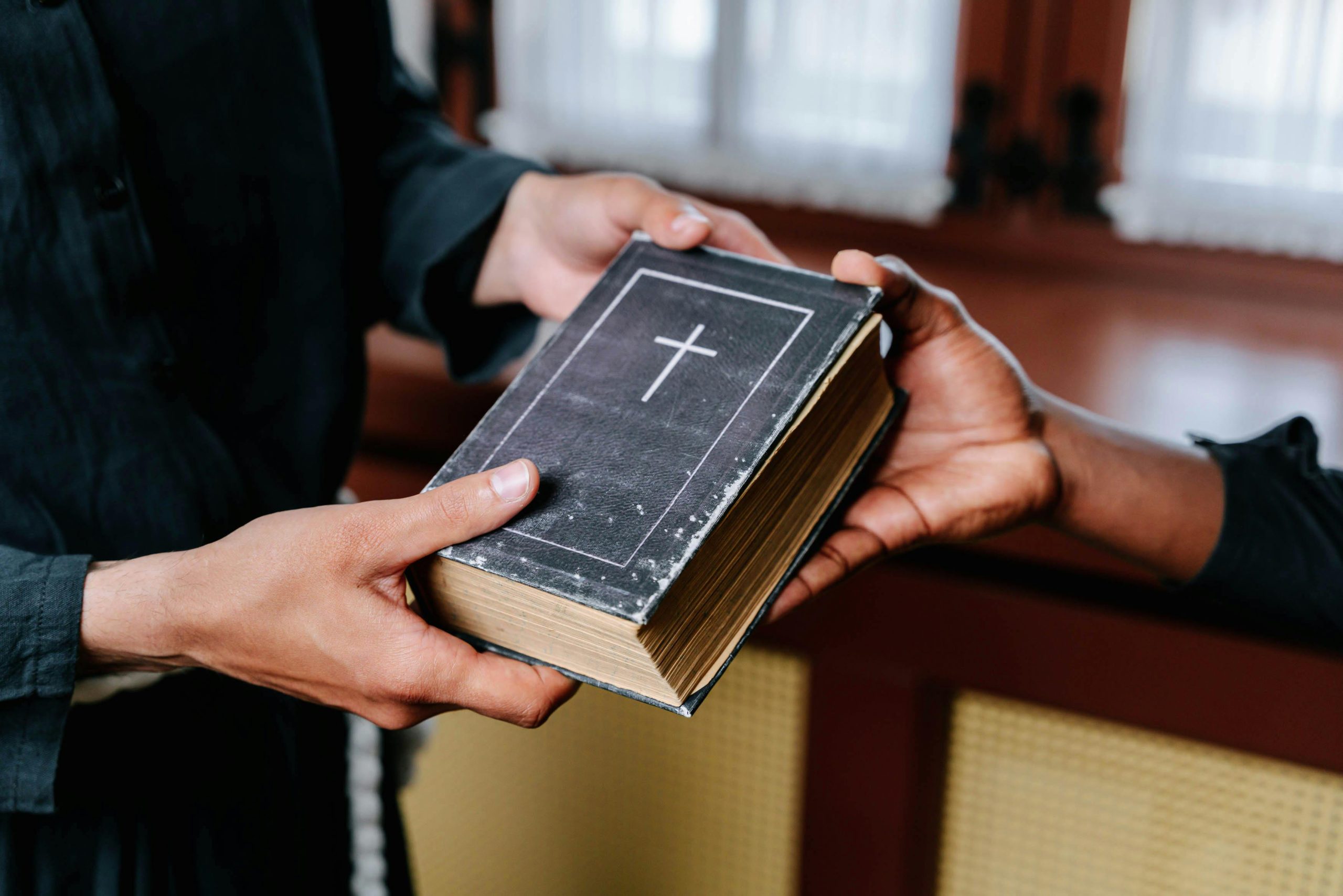 A man handing out the bible | Image Source: Pexels A man handing out the bible | Image Source: Pexels
